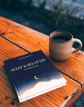 Sleep & Recovery guidebook by RanchWise beside a mug in evening light